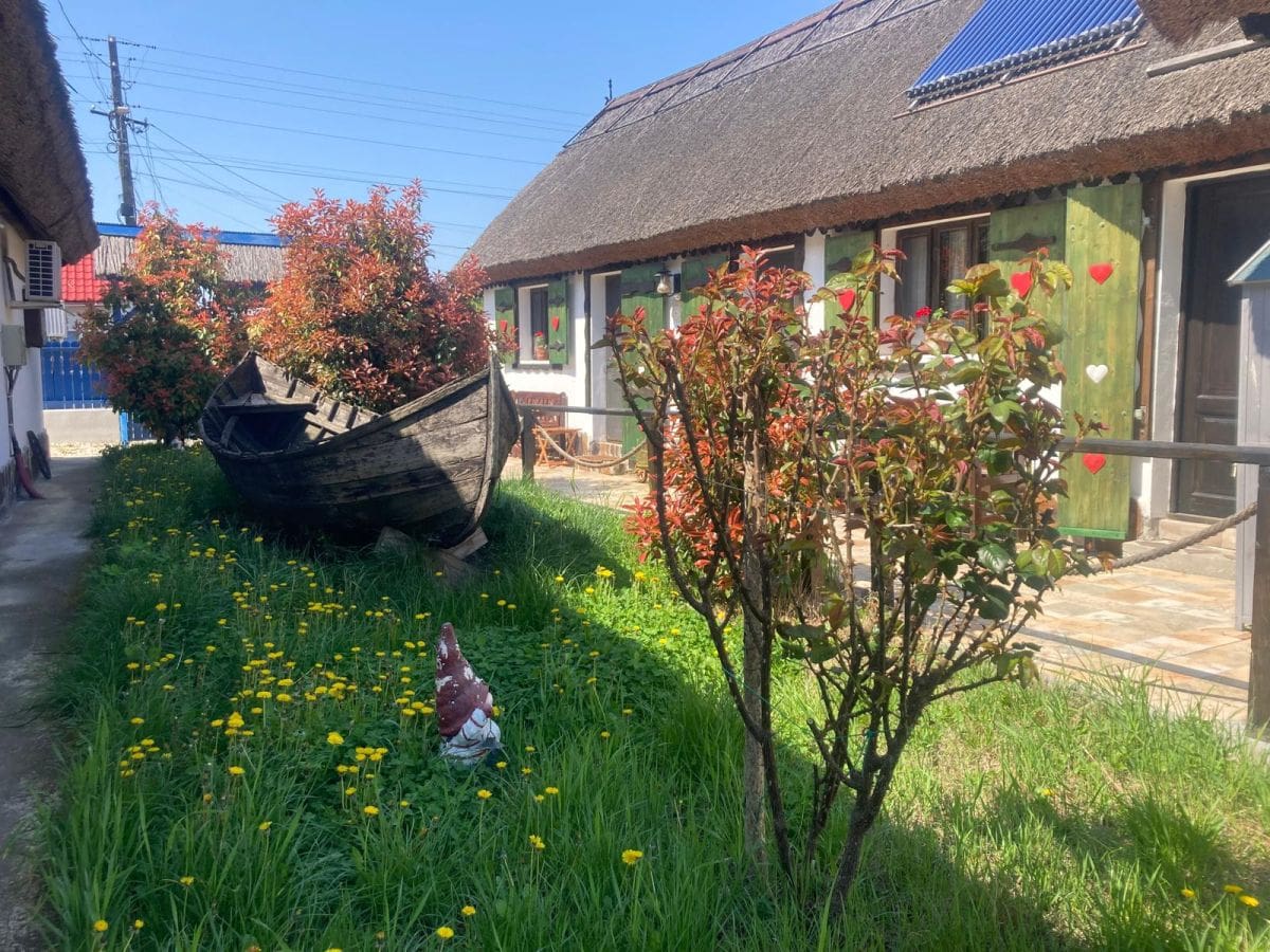 Barca cu vasle in curtea unei case lipovenesti din Marighiol, Delta Dunarii