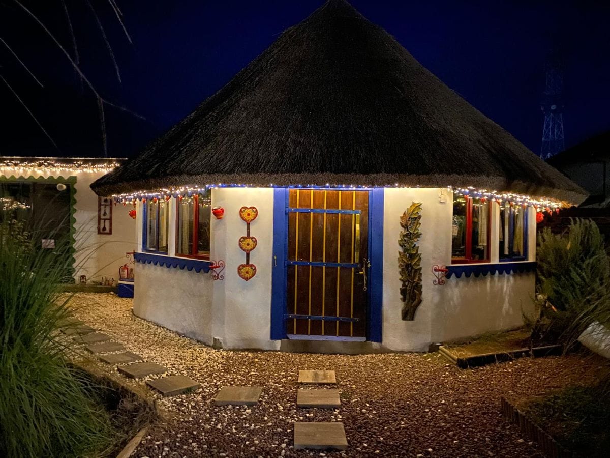 Foisor cu acoperis de stuf iluminat pe timp de noapte